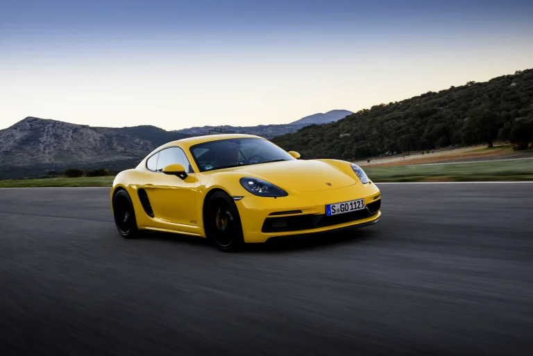 Желтый Porsche 718 Cayman GTS на скоростной трассе