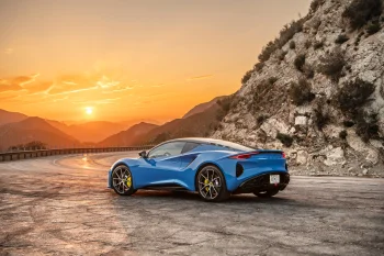 Синий Lotus Emira на извилистой горной дороге