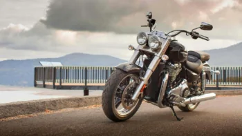 Черный круизер Triumph Thunderbird на фоне облачного горного пейзажа