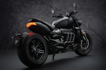 A matte black Triumph Rocket 3 with a lit taillight