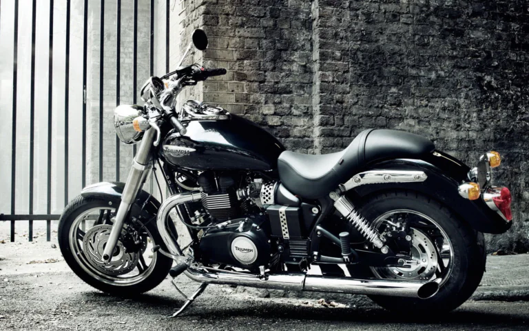 A black Triumph Speedmaster by an old brick wall