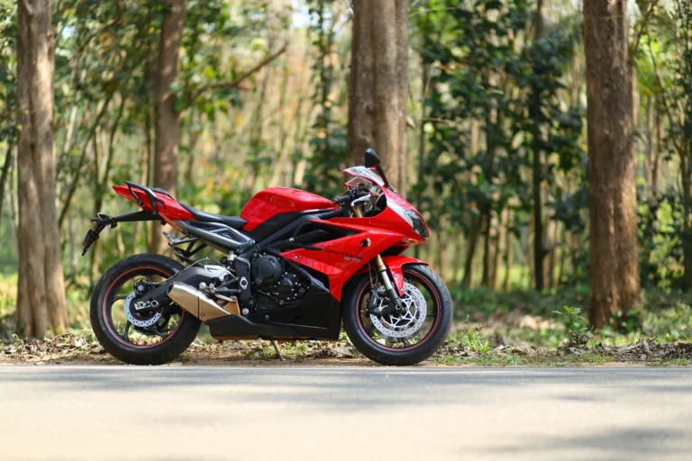 A bright red Triumph Daytona 675 on a forest road