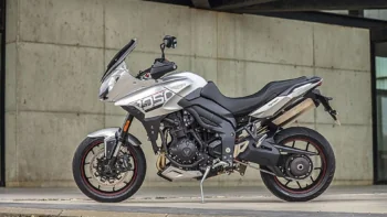 A silver Triumph Tiger Sport 1050 against a concrete wall