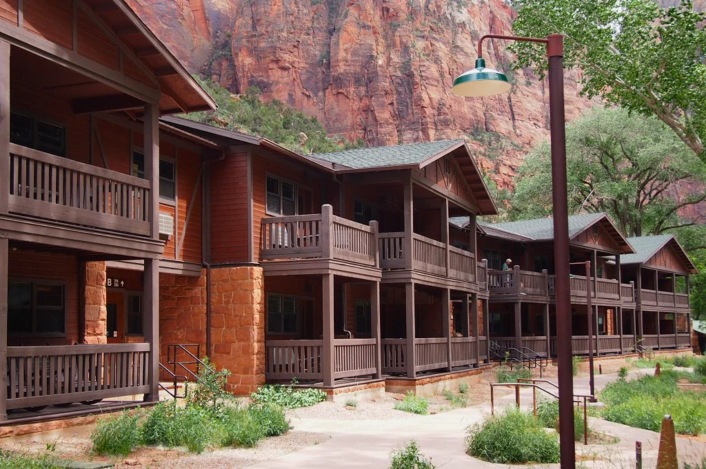 Дерев'яні будівлі Zion Lodge на тлі червоних скель у США