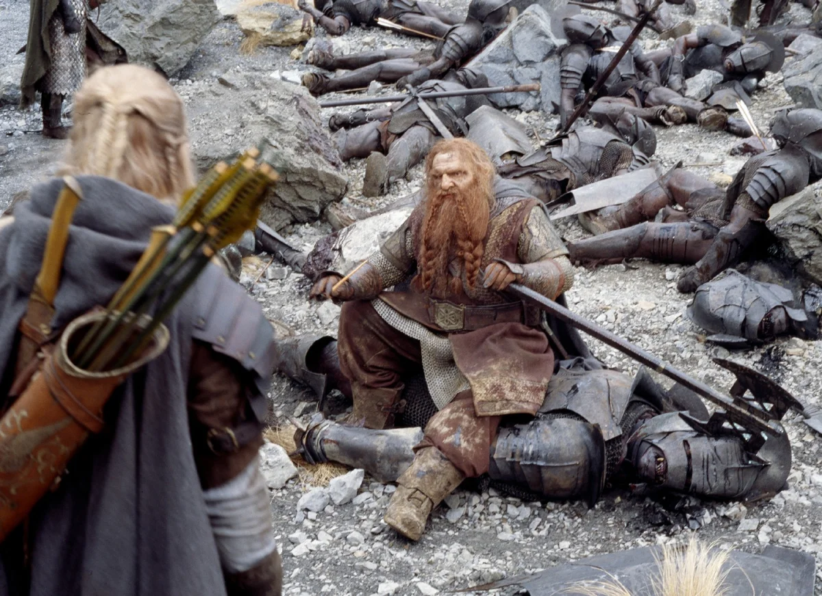 gimli is resting on the battlefield after the battle with the uruk-hai, the lord of the rings: two fortresses, armor, battles, fights, combats, cinema, elves, fantasy, stones, the lord of the rings, warriors, weapon, movies