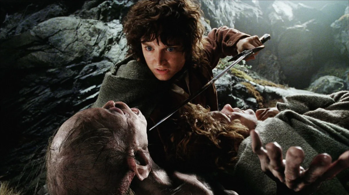 Frodo Baggins, wielding the sword Sting, confronts Gollum in the cave